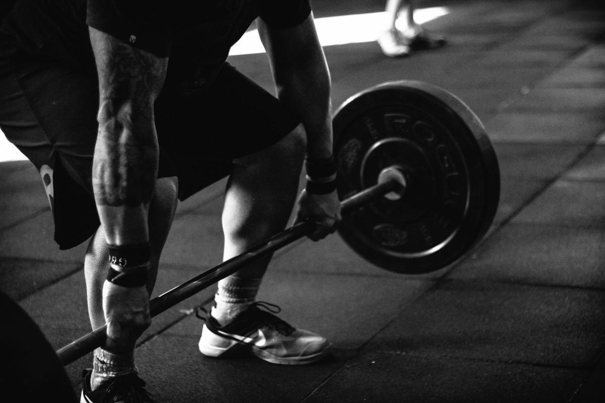 Man voert een deadlift uit als een van zijn compound oefeningen