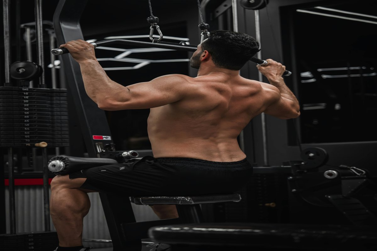 Man voert een lat pull down uit met correcte techniek in de sportschool