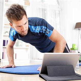 Man traint thuis met begeleiding van een online fitness coach via tablet