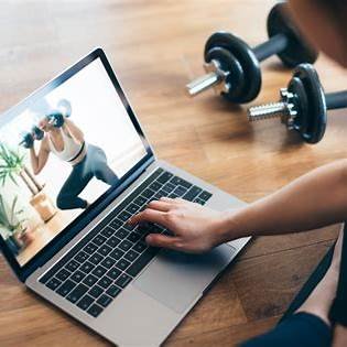 Persoon traint thuis met online personal trainer via laptop