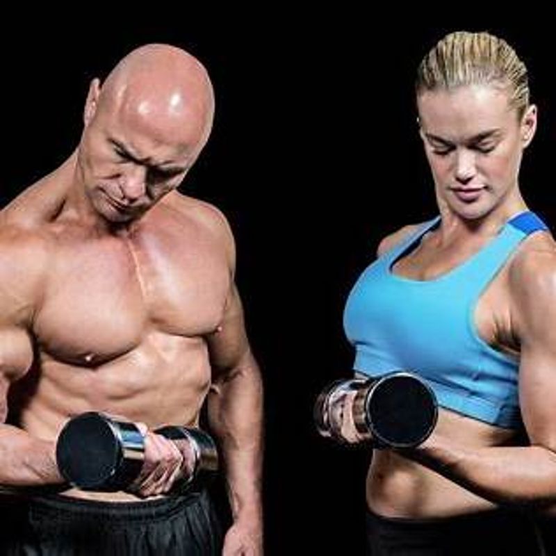 Man en vrouw voeren bicep curls uit voor spieropbouw
